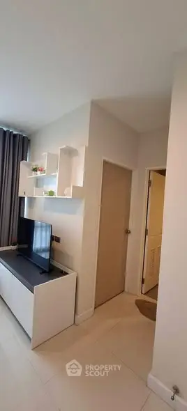 Modern living room with sleek white furniture and wall-mounted shelves