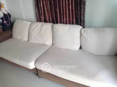 Spacious living room with comfortable beige sofa and elegant curtains