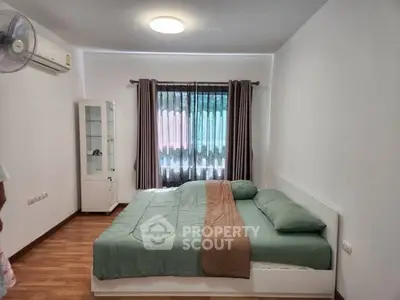 Cozy bedroom with modern decor and large window for natural light