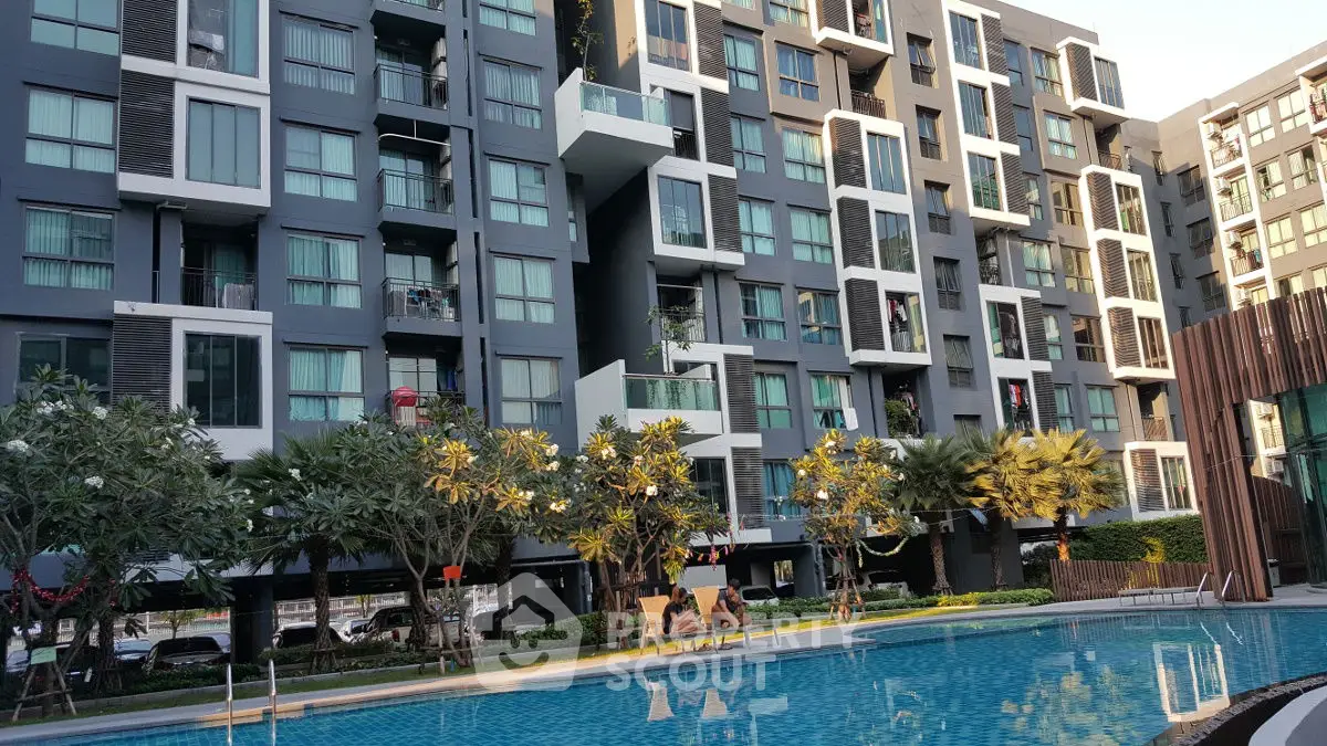 Modern apartment complex with pool and lush landscaping