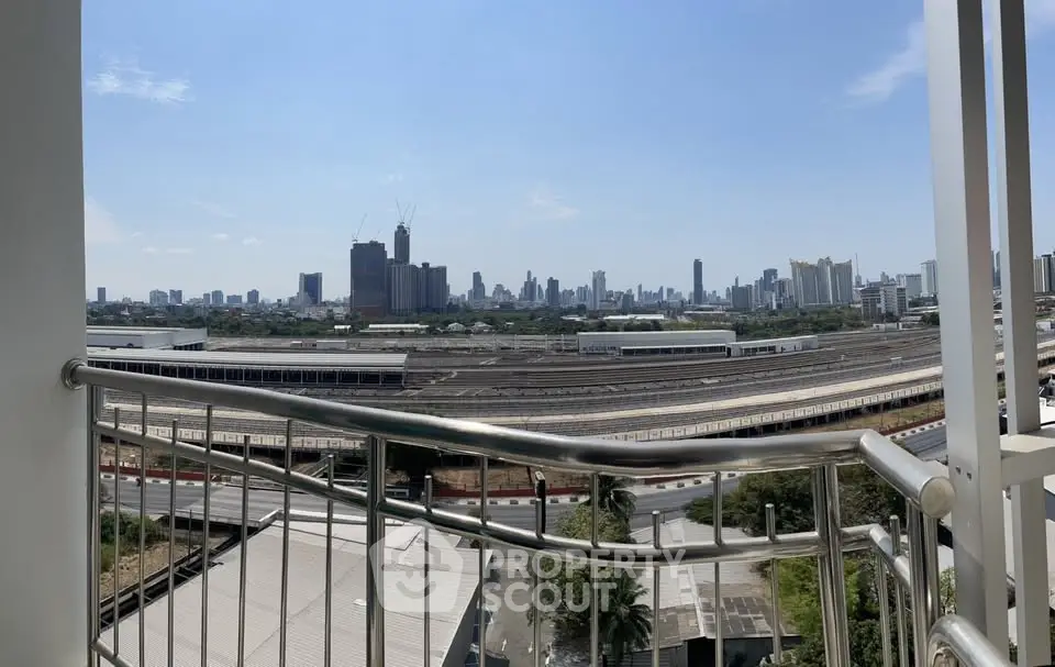 Stunning cityscape view from a modern balcony overlooking urban skyline and railway tracks.