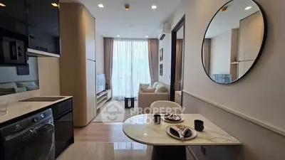 Modern open-plan living room with dining area and large window in stylish apartment.