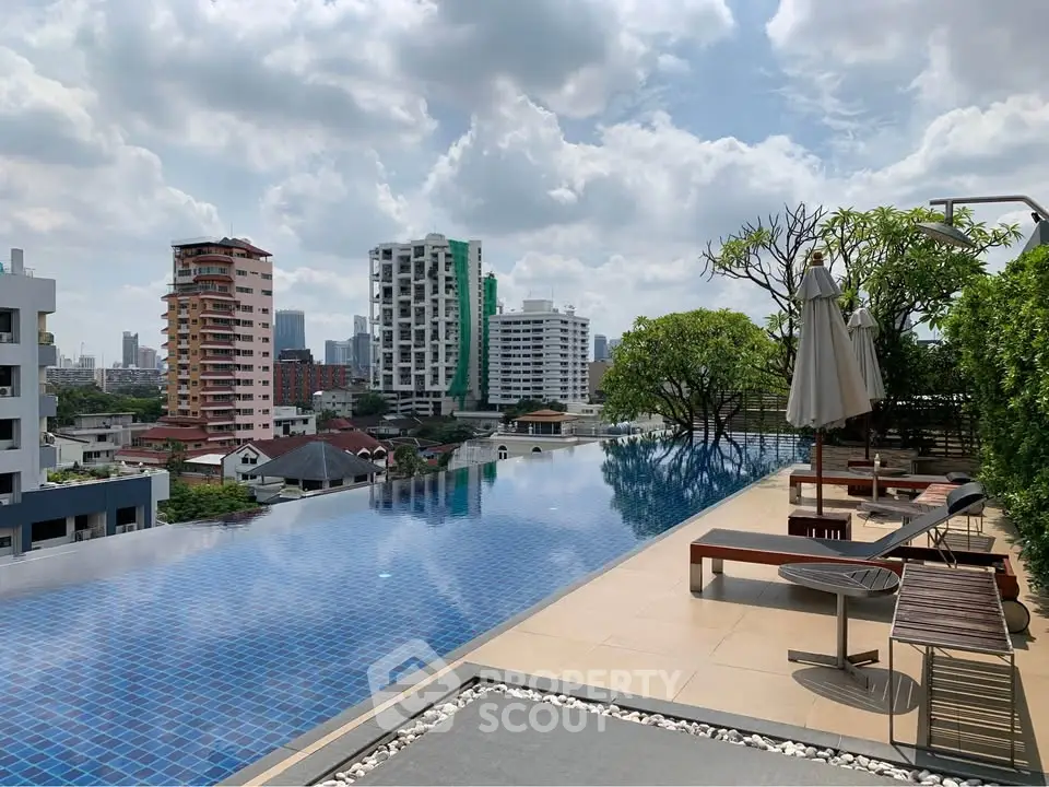 Luxurious rooftop infinity pool with stunning city skyline views and relaxing lounge area.