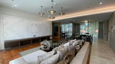 Spacious modern living room with elegant lighting and large windows offering a serene view.