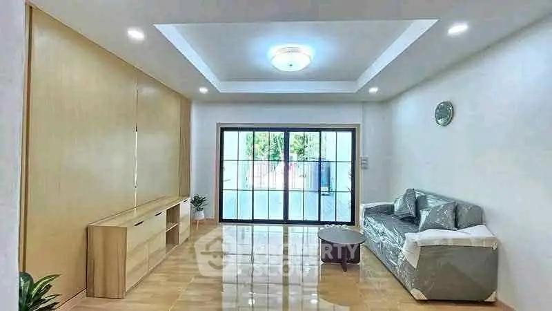 Spacious living room with modern decor and large sliding glass doors leading to a balcony.