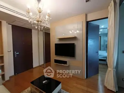 Elegant living room with chandelier and modern TV setup in luxury apartment