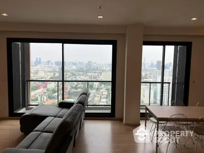 Stunning city view from modern high-rise apartment living room with sleek furniture.