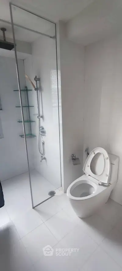 Modern bathroom with sleek shower and toilet in minimalist design.