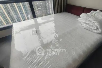 Spacious bedroom with large window offering city view and modern furnishings.
