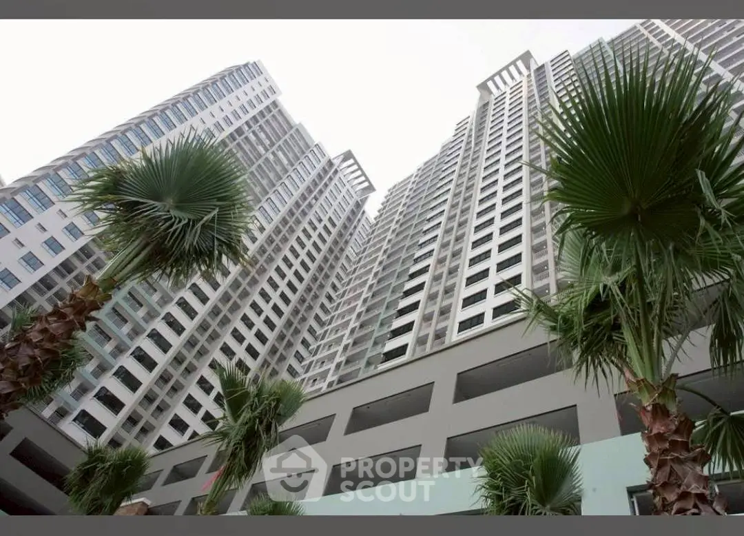 Stunning high-rise building exterior with modern architecture and lush palm trees.