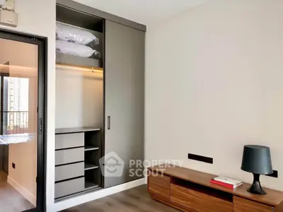 Modern bedroom with built-in wardrobe and sleek wooden furniture in a stylish apartment.
