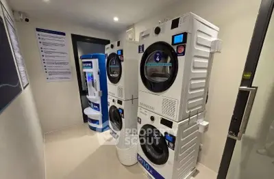 Modern laundry room with stacked washing machines and vending machine