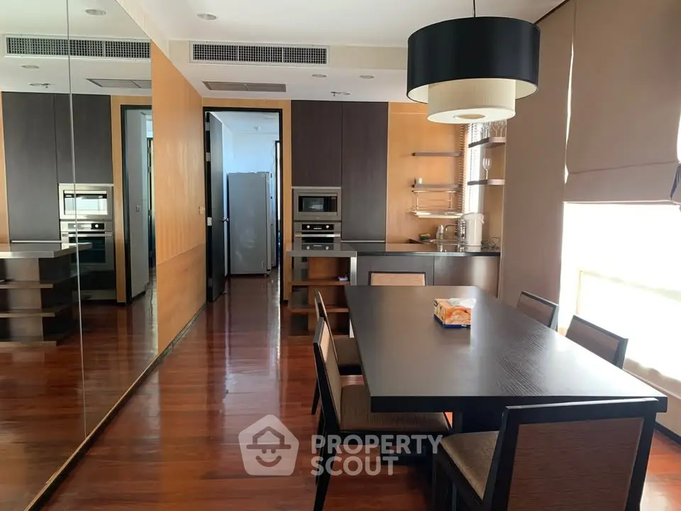 Modern kitchen with sleek design, featuring a dining table and built-in appliances, perfect for contemporary living.