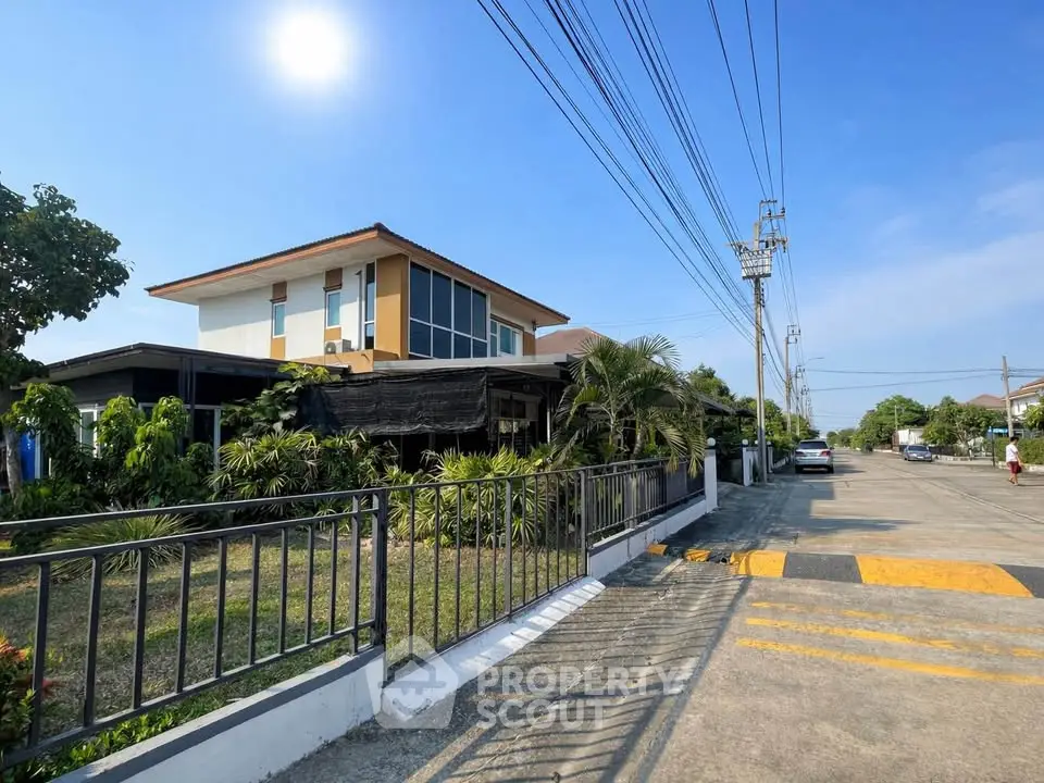 Modern two-story house with lush garden and sunny street view
