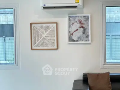 Modern living room with stylish wall art and air conditioning unit, perfect for comfortable living.