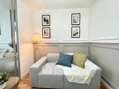 Cozy living room with modern decor and stylish wall art, featuring a comfortable sofa and elegant lighting.