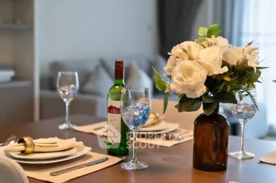 Elegant dining table setup with wine and floral centerpiece in a cozy living room.
