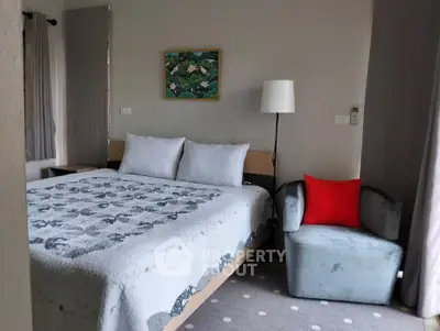 Cozy bedroom with stylish decor and comfortable seating in modern apartment.