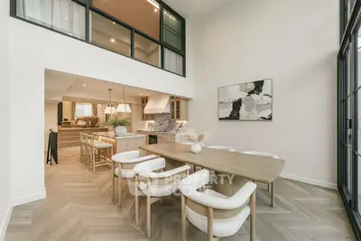 Luxurious open-plan dining area with modern decor and high ceilings, perfect for entertaining.