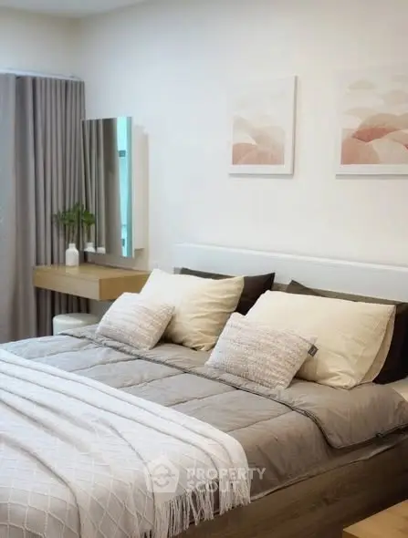 Elegant bedroom with modern decor, featuring a cozy bed, stylish artwork, and a sleek vanity area.