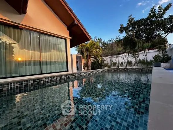 Stunning poolside view at sunset with modern architecture and lush greenery.