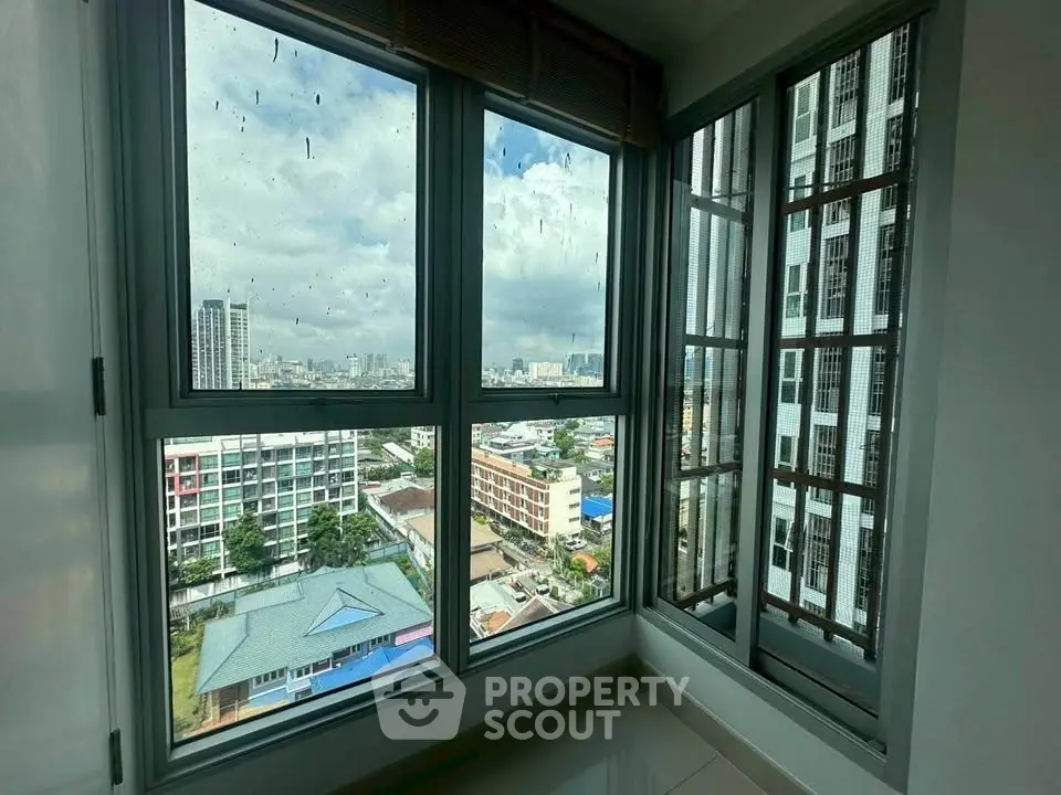 Stunning city view from high-rise apartment window, offering a panoramic urban landscape.