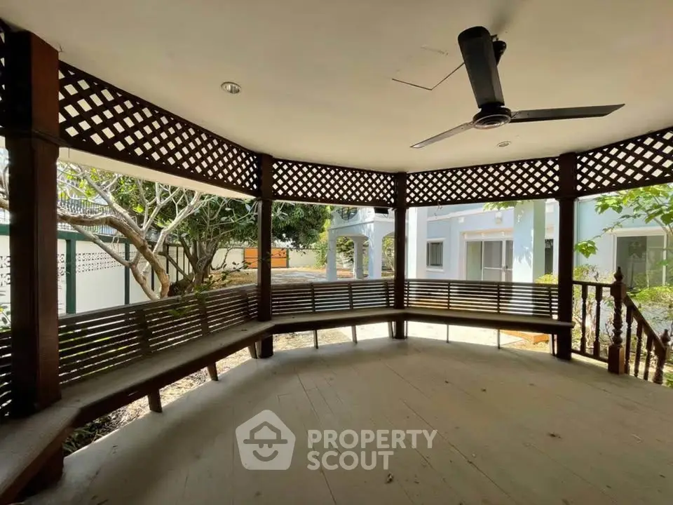 Charming wooden gazebo with ceiling fan in serene garden setting