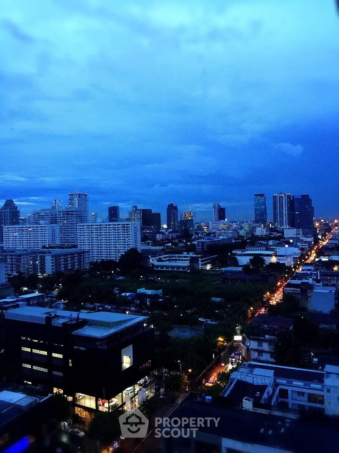 Stunning cityscape view from high-rise building at dusk, showcasing urban skyline and vibrant city lights.