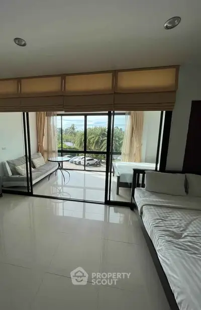 Spacious living room with large windows and balcony offering a stunning view.