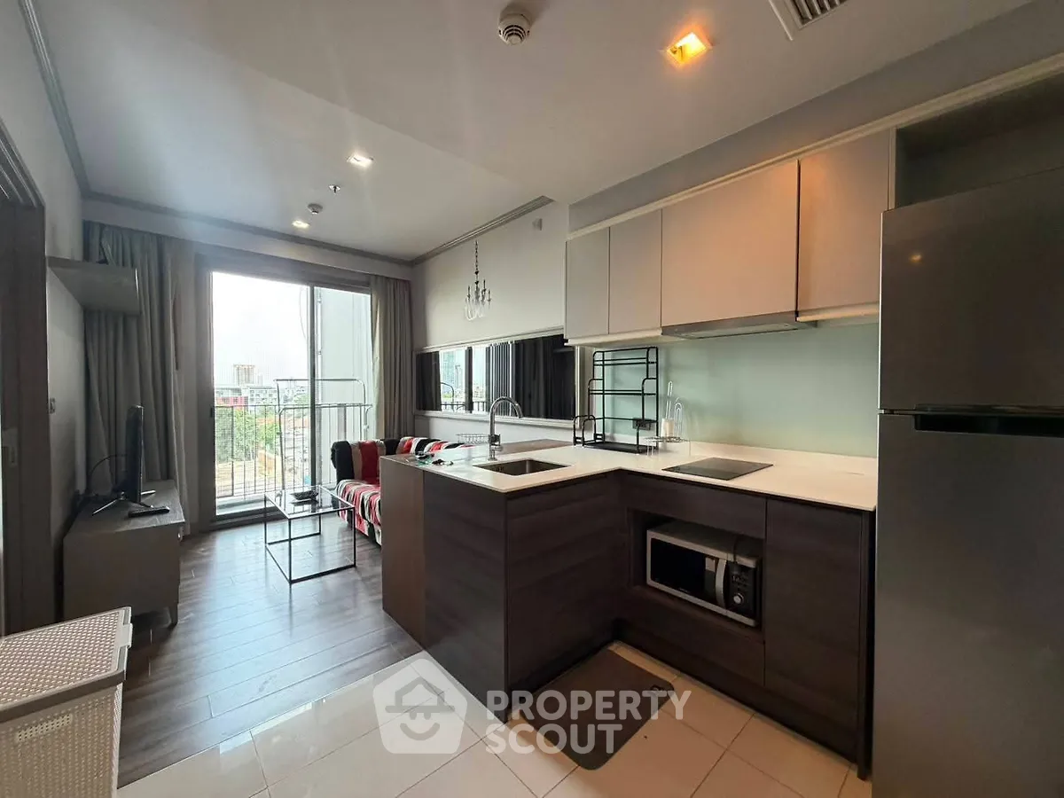 Modern open-layout kitchen with sleek appliances and cozy living area, perfect for urban living.