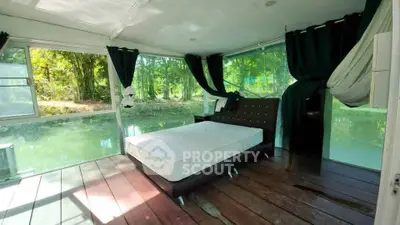 Stunning bedroom with floor-to-ceiling windows offering serene forest views, perfect for nature lovers.