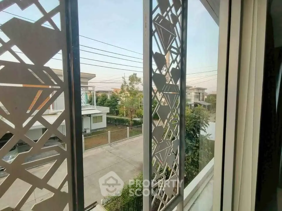 Modern residential view from window with decorative paneling and street view.