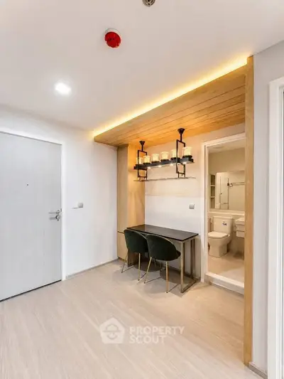 Modern apartment interior with stylish study area and bathroom entrance, featuring sleek design and warm lighting.