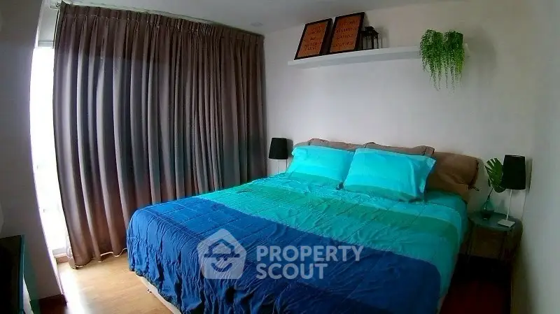 Cozy bedroom with large bed, stylish decor, and natural light from window.