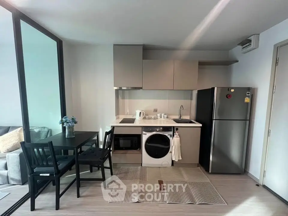 Modern kitchen with dining area, featuring sleek appliances and stylish decor.