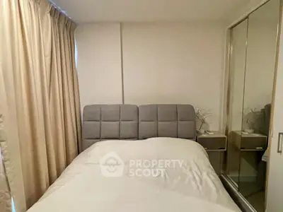 Cozy bedroom with mirrored wardrobe and neutral curtains