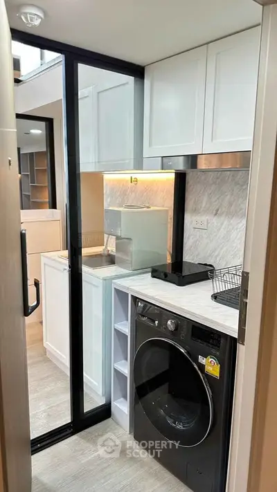 Modern compact kitchen with washing machine and sleek cabinetry
