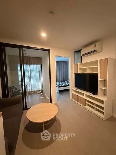 Modern living room with sliding glass doors and stylish furniture in a cozy apartment.