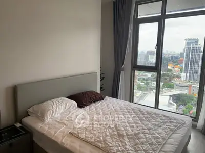 Modern bedroom with large window offering stunning city view, featuring a cozy bed and elegant curtains.