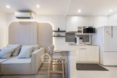 Modern open-plan living room and kitchen with sleek design and neutral tones.