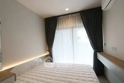 Modern bedroom with elegant curtains and air conditioning, featuring a cozy atmosphere.