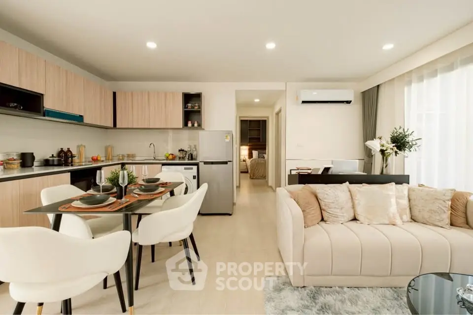 Modern open-plan living room and kitchen with elegant decor and natural light.