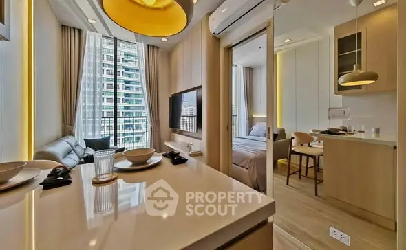 Modern open-plan apartment with sleek kitchen and cozy living area, featuring large windows and city views.