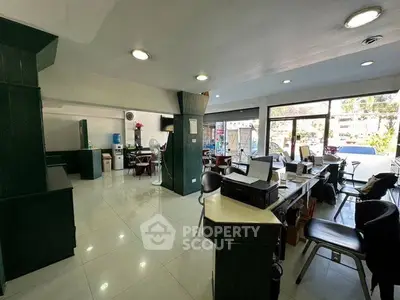 Spacious office space with modern furnishings and large windows for natural light.