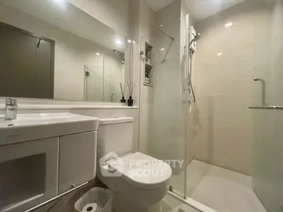 Modern bathroom with glass shower and sleek fixtures in a contemporary apartment.