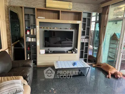 Spacious living room with modern entertainment center and cozy seating area.