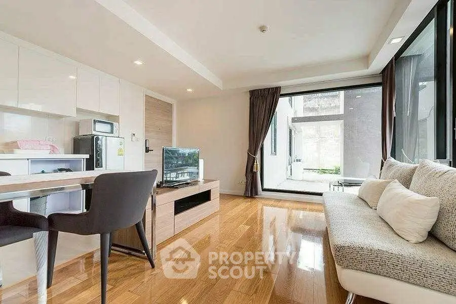 Modern living room with sleek furniture and large windows offering natural light.