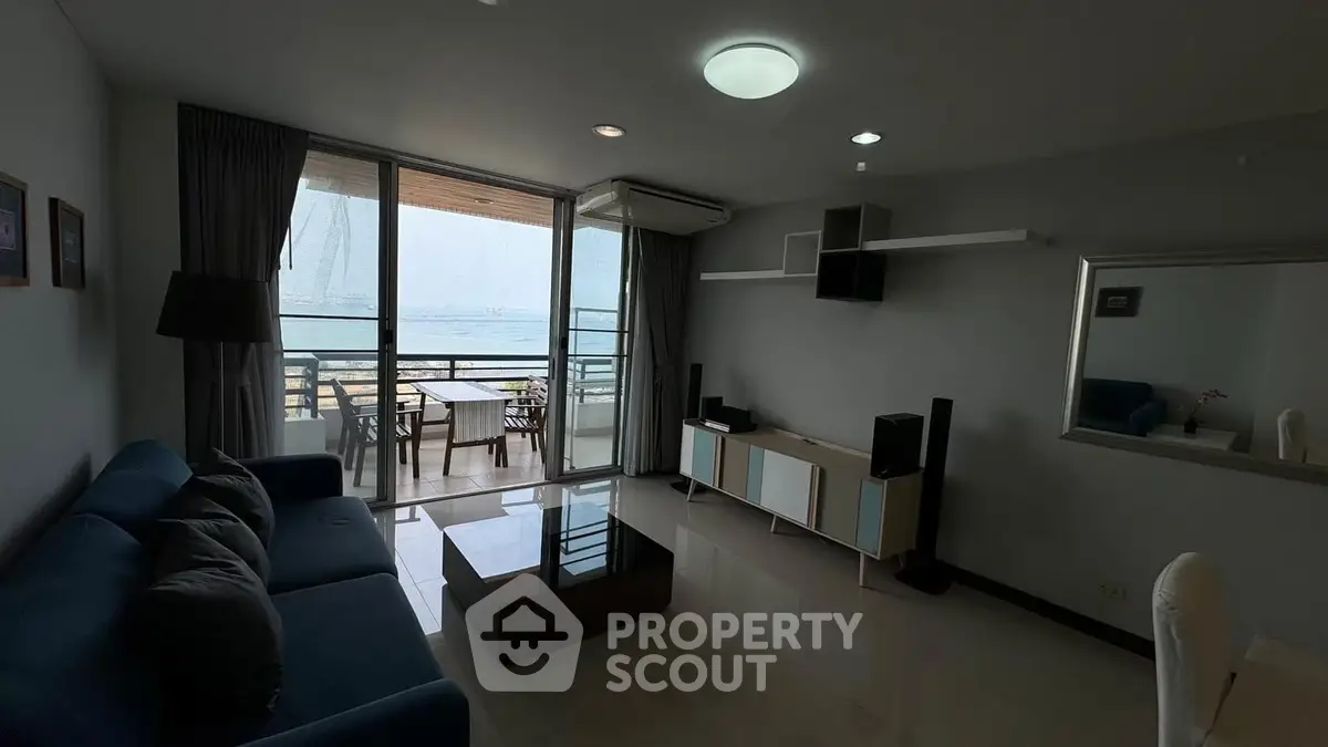 Spacious living room with modern decor and stunning sea view balcony.