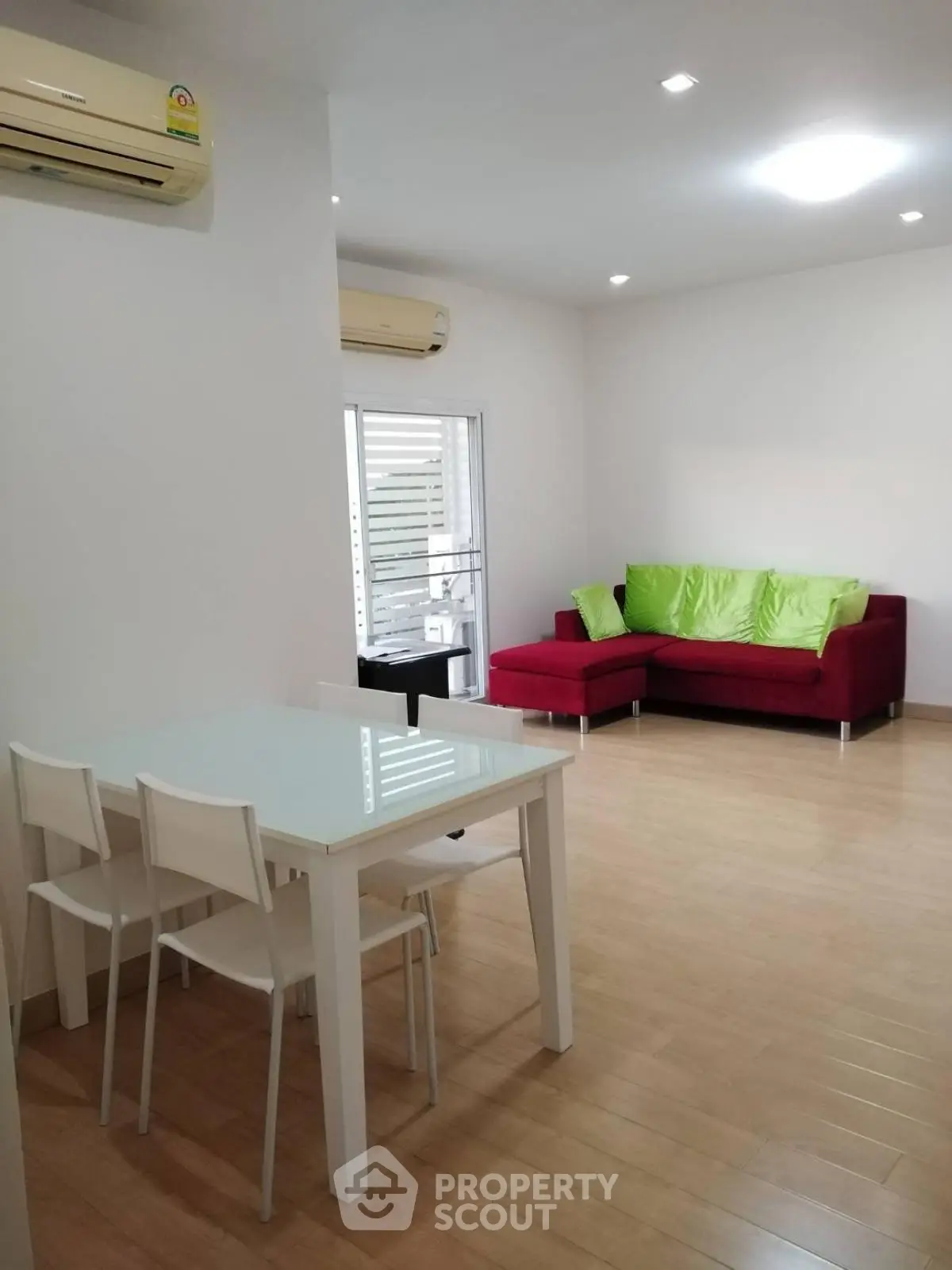 Modern living room with red sofa and dining area, featuring sleek design and bright ambiance.