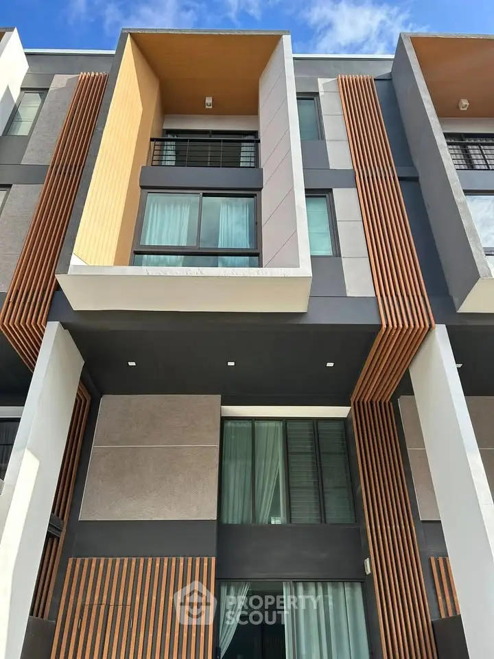 Modern multi-story building exterior with stylish facade and large windows, showcasing contemporary architectural design.